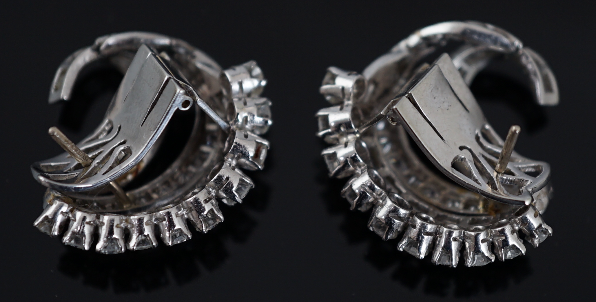 A pair of platinum? and diamond cluster set scrolling earrings